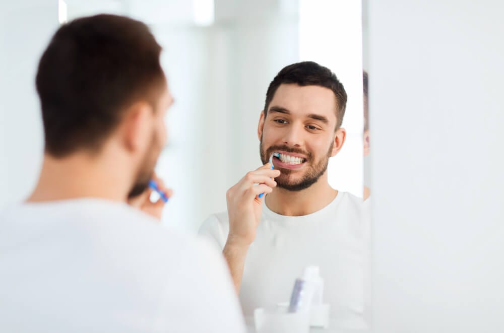 A man that is brushing his teeth